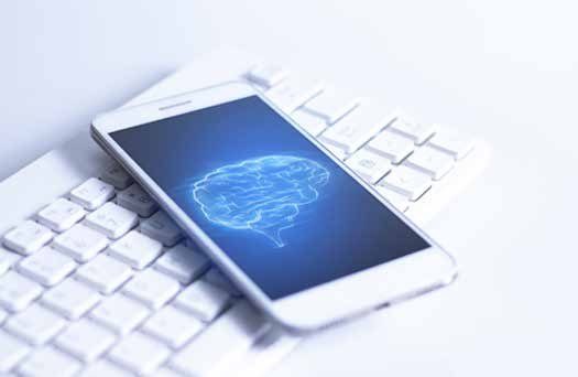 A smartphone showing a brain image resting on a keyboard